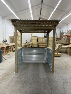 the inside of a building with metal slats and wood pallets on the floor