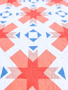 a red, white and blue quilt is on display