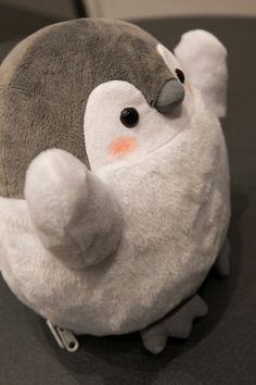 a stuffed penguin sitting on top of a table