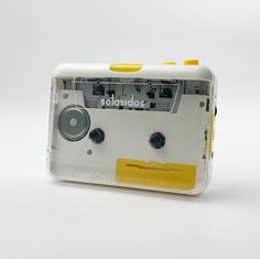 an old fashioned radio sitting on top of a white table next to a yellow tape dispenser