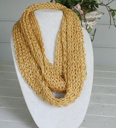 "Light weight hand knitted infinity scarf fits any body size.  Measures 62\" around and 6 1/2\" in width.  Because this scarf is so lightweight it's perfect for wearing all day long as an accessory.  The scarf color is a beautiful gold color.  This yarn is vey soft and the knit makes it lacy.   The yarn is made of 100% Acrylic; And YES, it's washable...  Machine wash warm gentle cycle, Do Not bleach, Do Not Iron, Tumble Dry Low Heat, Dry Clean Any Solvent except Trichloroethylene." One Size Yarn Infinity Scarf, Hand Knitted Yarn Infinity Scarf, One Size, Hand Knitted Infinity Scarf, Hand Knitted One Size Infinity Scarf, One Size Hand Knitted Yarn Infinity Scarf, Hand Knitted One-size Infinity Scarf, Hand Knitted Yarn Infinity Scarf, Golden Scarf, Scarf Fits