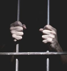 two hands holding bars in front of a black background