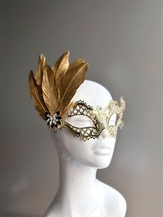 Rhinestones delicately embellish this gold women's masquerade mask, adding a touch of sparkle to your elegance. Golden feathers adorn the mask with an elegant brooch. Crafted with detail, this mask showcases the enchanting allure of gold, making you a captivating presence at any masquerade event.


Age Group/Gender - Adult/Women

Size/Type - One size fits all adults

Mask Color - Gold

Mask Material - Laser Cut Metal

Accent Material - Paint

Special Features - Feathers and a brooch Gold Headpieces For Costume Party And Carnival, Vintage Gold Masks For Costume Party, Elegant Feathered Eye Mask For Masquerade, Vintage Gold Masks And Prosthetics For Costume Party, Elegant Feathered Masquerade Mask For Mardi Gras, Elegant Feathered Masquerade Mask, Elegant Carnival Headpieces With Feathers, Vintage Gold Masks And Prosthetics For Masquerade, Elegant Adjustable Masquerade Mask For Mardi Gras