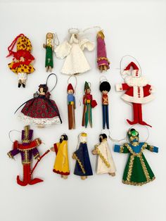 a collection of christmas ornament dolls and figurines, all in different colors