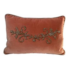 an orange pillow with embroidered flowers on it