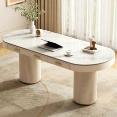 a white table with a laptop on it in front of a curtained window next to a rug