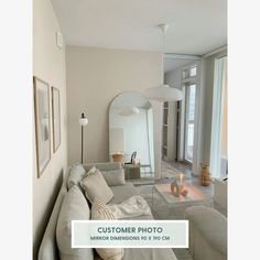 a living room filled with furniture and a large mirror above the couch in front of it