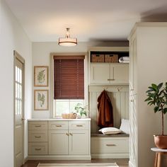 a room with white cabinets and brown blinds on the windowsills is shown in this image