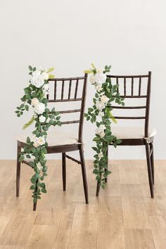 two chairs decorated with flowers and greenery