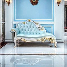 a white and blue couch sitting in a room next to a clock on the wall