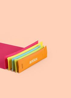 an orange, yellow, and pink folders are stacked on top of each other