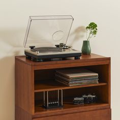 a record player on top of a wooden shelf