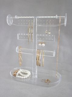 a clear display case holds several pairs of earrings and bracelets, including one earring