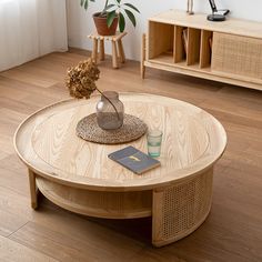 an advertisement for a coffee table with a book and vase on the top, in front of a wooden floor