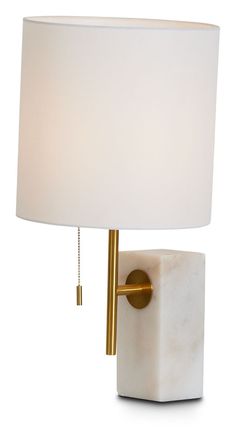 a table lamp with a white shade on the base and a gold metal rod attached to it