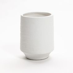 a white vase sitting on top of a table