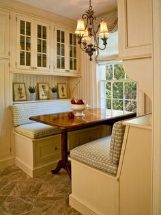 a kitchen with white cabinets and a wooden table