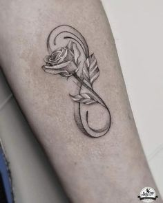 a rose with an arrow tattoo on the arm