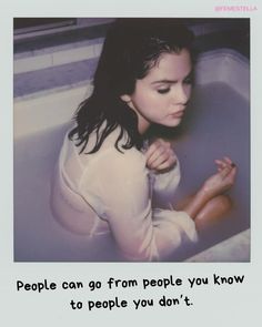 a woman sitting in a bathtub with her hands on her chest