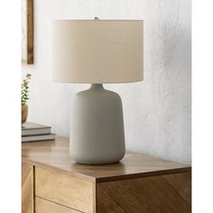 a table lamp sitting on top of a wooden dresser