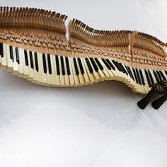 a piano made out of wooden strips on a white surface with black handles and feet