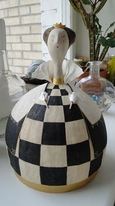 a black and white checkered pot with a gold crown on it's head