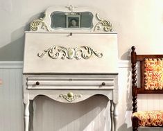 an antique white vanity and chair in a room