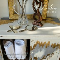 an old dresser is decorated with gold and white paint