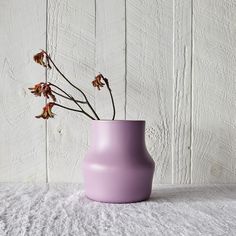 a purple vase with some flowers in it