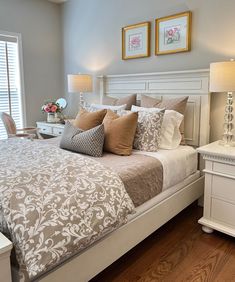 a white bed sitting next to a window in a bedroom on top of a hard wood floor