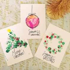 three christmas cards with watercolor designs on them