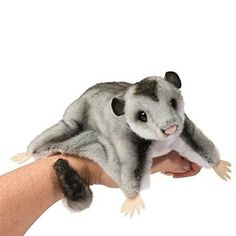 a hand holding a stuffed animal in it's palm