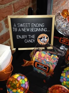 a table with candy, candies and a sign that says sweet ending to an new beginning enjoy the candy