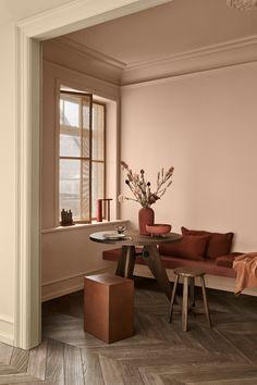 a living room filled with furniture next to a wooden table and window covered in curtains