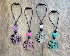 three necklaces with the words ma ma and leopard print are shown on a wooden surface