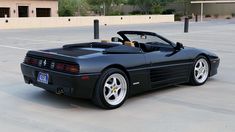 a black sports car parked in a parking lot with no one around it's seats