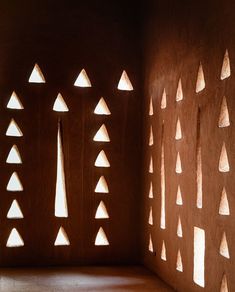 the light is shining through the windows on the wall in the room with many triangular shapes