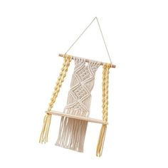 a white macrame hanging from a wooden pole with tassels and beads