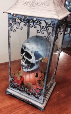 a lantern with a skull inside on a table