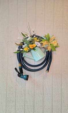 a blue hose connected to a white wall with flowers and plants in it on top