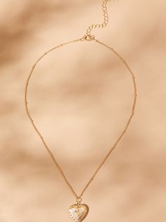 Cherish your memories with our heart-shaped locket necklace. It has vintage charm with its antique finish. This timeless piece features a delicate frame, ready to hold your cherished photo close to your heart. Antique Gold Heart Necklace With Vintage Charm, Dainty Necklace With Vintage Heart Pendant, Dainty Necklace With Heart Pendant And Vintage Charm, Antique Gold Heart Pendant Necklace For Valentine's Day, Antique Gold Necklace With Heart Charm For Valentine's Day, Antique Gold Necklace With Heart Charm, Antique Gold Necklace With Heart Pendant, Elegant Antique Gold Heart Pendant Necklaces, Antique Gold Engraved Heart Pendant Necklace