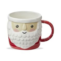 a coffee cup with a santa claus face on the front and sides, sitting in front of a white background