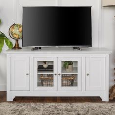 a flat screen tv sitting on top of a white entertainment center