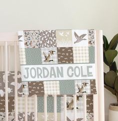 a baby crib with a bird theme and the name jordan cole written on it