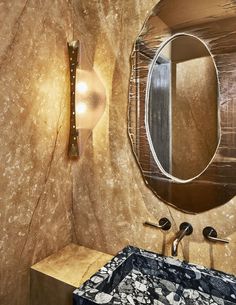 a bathroom with a sink, mirror and lights on the wall next to each other