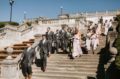 a group of people that are walking down some steps together in suits and ties,