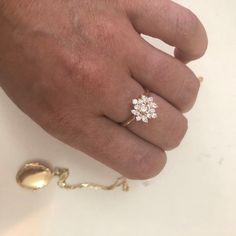 a person's hand with a diamond ring on it