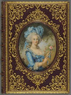 an ornately decorated book with a woman holding a flower in her hand and wearing a blue