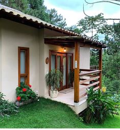 a small house with plants and flowers in the front yard