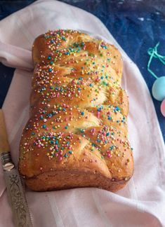 a loaf of bread with sprinkles next to a knife